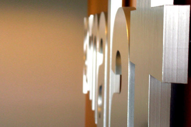 Parmalat thick 3D brushed metal signage letters raised off the office lobby reception area wall on risers