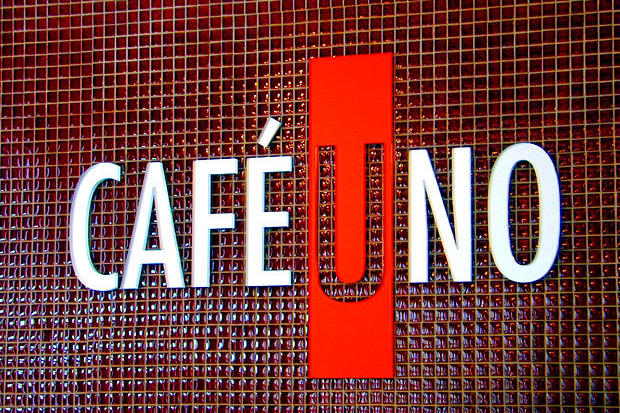 Dimensional acrylic lettering signage for cafe logo mounted directly to lobby wall by cash register