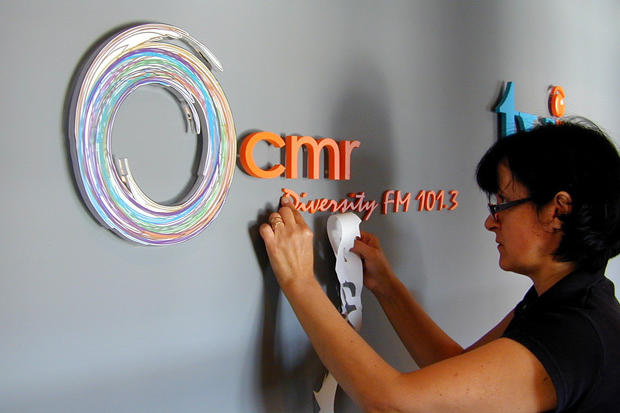 Lobby sign installers preparing acrylic 3D signage letters on office reception wall - Tamil Vision Int. - Art Sign Company