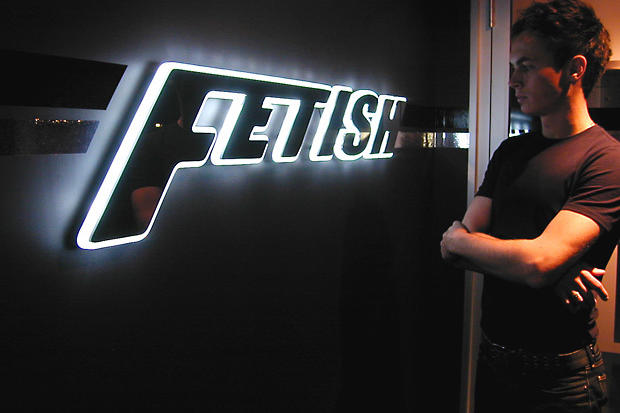 Man looks at LED back lit lobby sign at night with halo glow around laser cut acrylic lettering - Circa Night Club - Art Signs Company