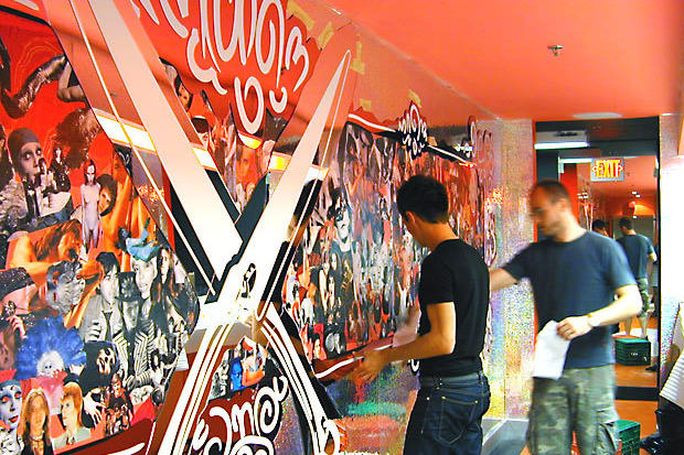 Installers installing laser cut mirrored acrylic art on wall at Circa night club