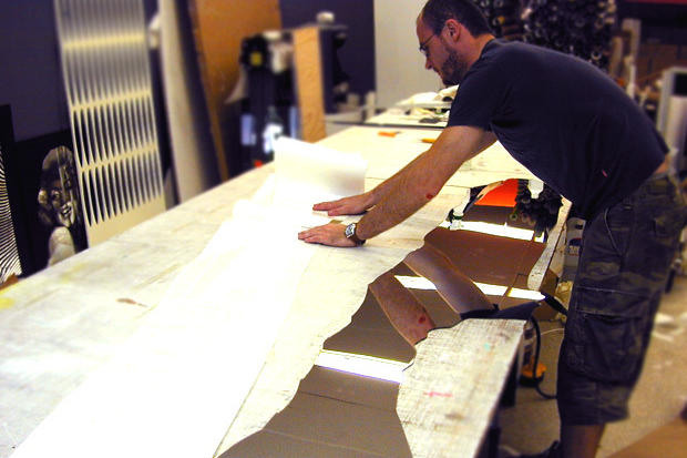 Installers making laser cut decorative acrylic wall art with custom vinyl graphics