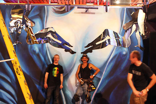 Two installers proudly display decorative mirrored laser cut acrylic mud flap girl silhouettes in night club - Circa Toronto