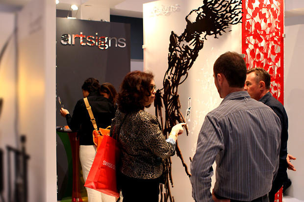 Interior designers gathering around laser cut stained wood art design on frosted acrylic background with laser cut cutouts - Art Signs Company