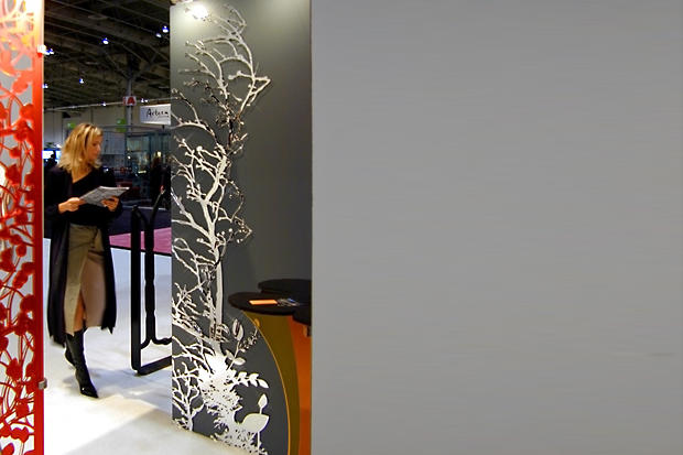 Interior designer looking at decorative laser cut mirror panel at IIDEX interior design show in Toronto - Art Signs Company