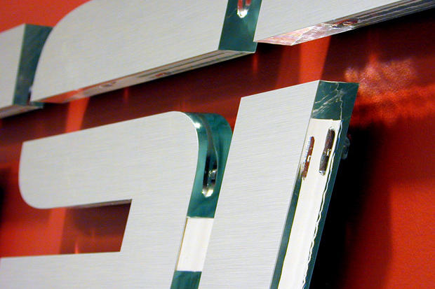 Close up of cut brushed metal film on laser cut acrylic signage lettering raised off lobby reception area wall.