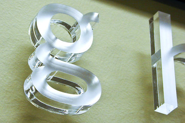 Letter G in lobby signage made with metal effect acrylic sign letters raised off office reception wall - Art Signs Company