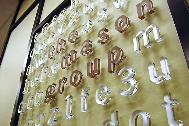 Close up of raised acrylic lobby signage on reception area wall in corporate business office