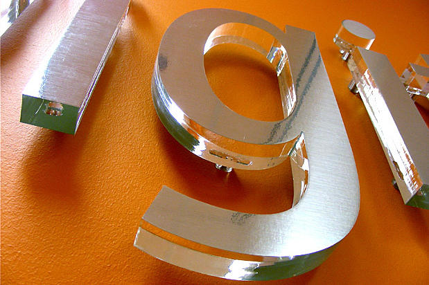 Lavadigital Decorative brushed metal finish signage lettering design with raised letters off office lobby reception area wall. Sign made by Art Signs Company