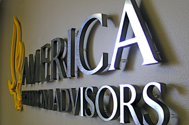 3D metal office lobby signage with raised laser cut sign lettering behind reception desk in business