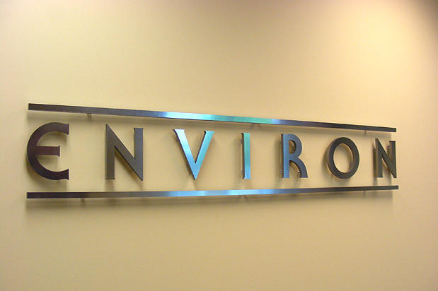 Chrome metal company reception signage in corporate office lobby area raised on spacers off wall and made by Art Signs Company