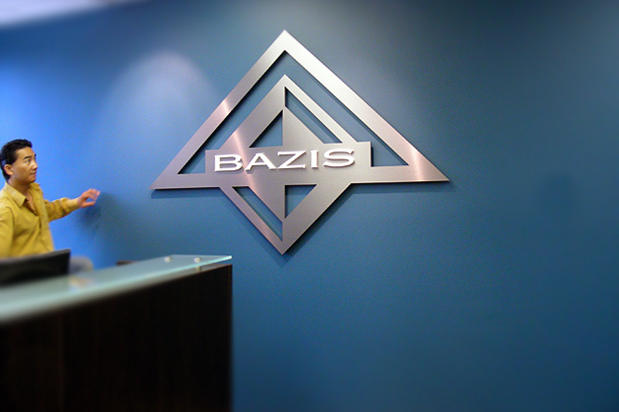 Interior designer looking at metal signage product with customized logo and letters mounted on the wall