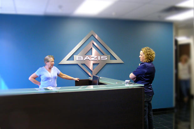 Customer complementing sign installers on new custom signs in their office lobby