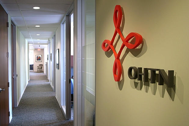 3d company logo signage raised on reception wall and lit by halogen spot lights