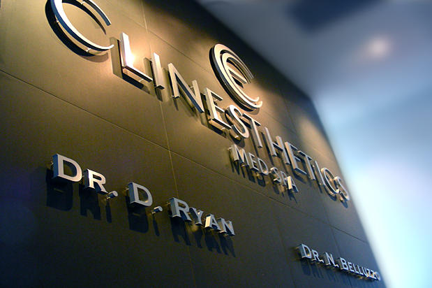 3D office lobby sign brushed metal mounted to tile wall in spa reception area