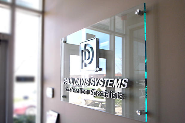 3D corporate office sign on green edge acrylic background with 4 decorative stainless steel spacers