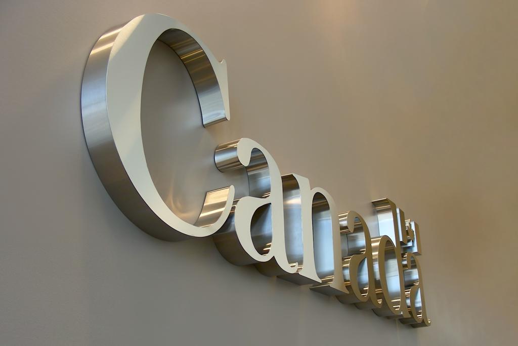 Custom design metal sign with three-inch deep stainless steel letters on an office wall, premium signage metal.The high-quality metal finish reflects light, creating a sleek and professional appearance.