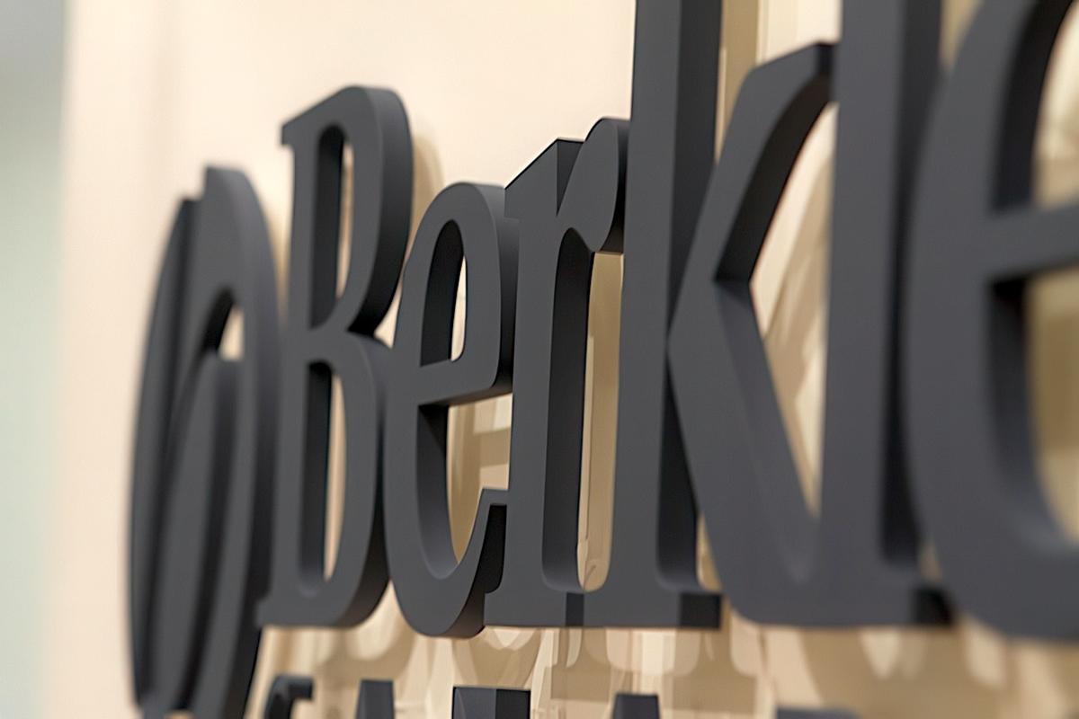 3D custom acrylic office wall sign with custom-matched dark grey paint, raised letters and logo mounted with spacers for a modern corporate environment.