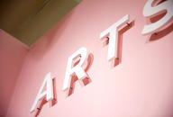 White plastic sign letters raised off pink color art show wall that say ART
