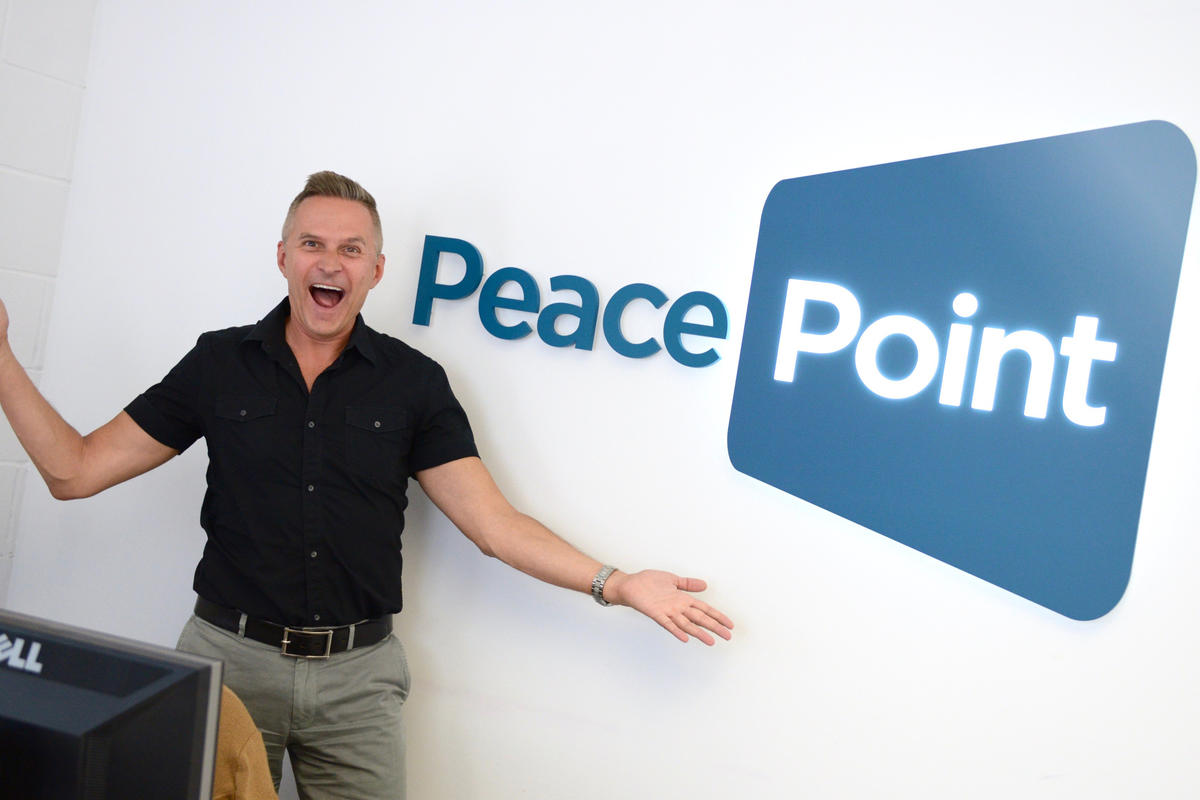 Happy customer with lighted 3D wall sign "Peace Point"