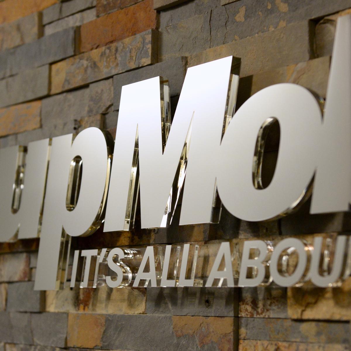 Chrome mirror dimensional sign letters on stone wall