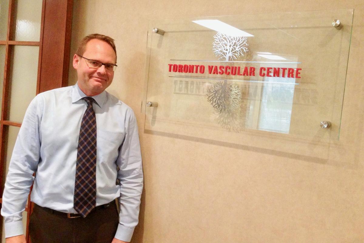 Smiling client standing next to Acrylic Panel Sign with Metal logo