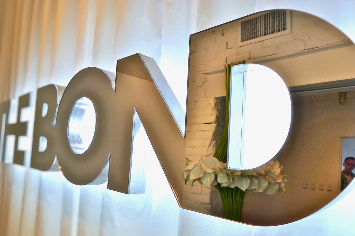 3D Backlit mirror sign letters raised through reception area drapes.