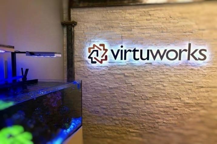 Backlit lobby sign mounted on ledge stone wall in reception area