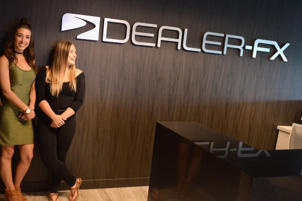 3D office reception sign for Dealer-FX on wooden reception wall with Becky Duncan and Jessie Mitchell