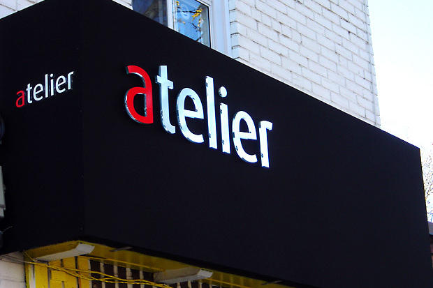 Dimensional acrylic lettering raised on retail store sign for business Atelier