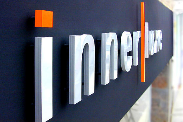 Dimensional metal letters on exterior retail sign with color acrylic logo symbols