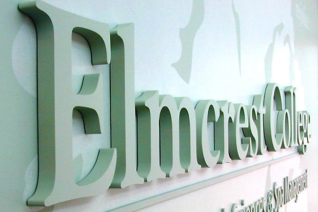 Office lobby sign made of painted laser cut dimensional lettering with custom wall decals.