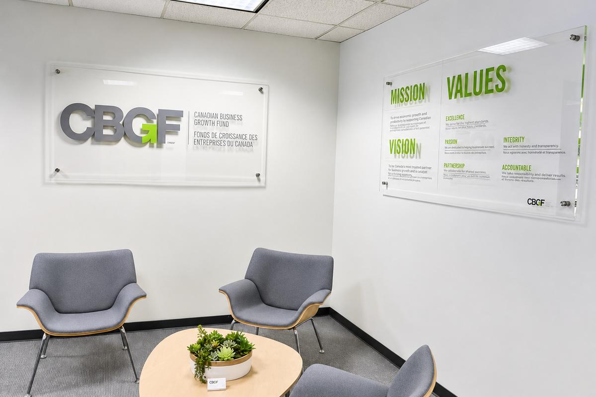 Clear acrylic panel with vinyl logo and company values mounted to wall in reception area