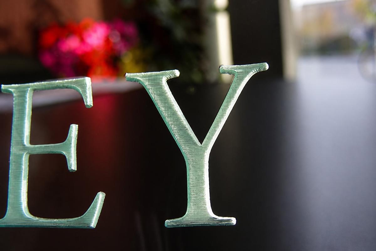 Macro detail of deep engraving on a ½-inch green-edge acrylic desktop nameplate