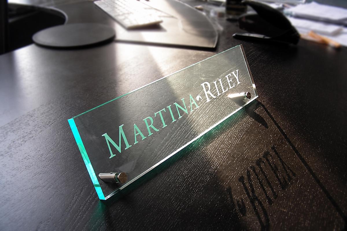 Martina Riley acrylic office nameplate viewed across a dark wood desktop