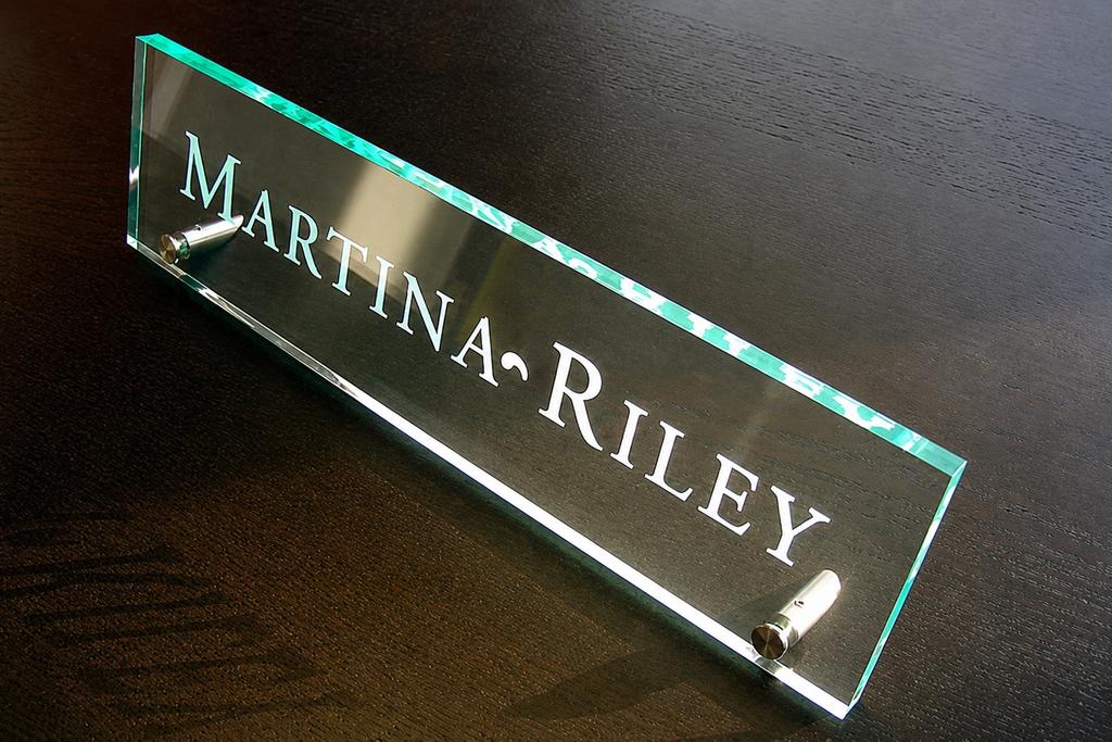 High-angle Martina Riley green-edge acrylic nameplate with stainless-steel brackets