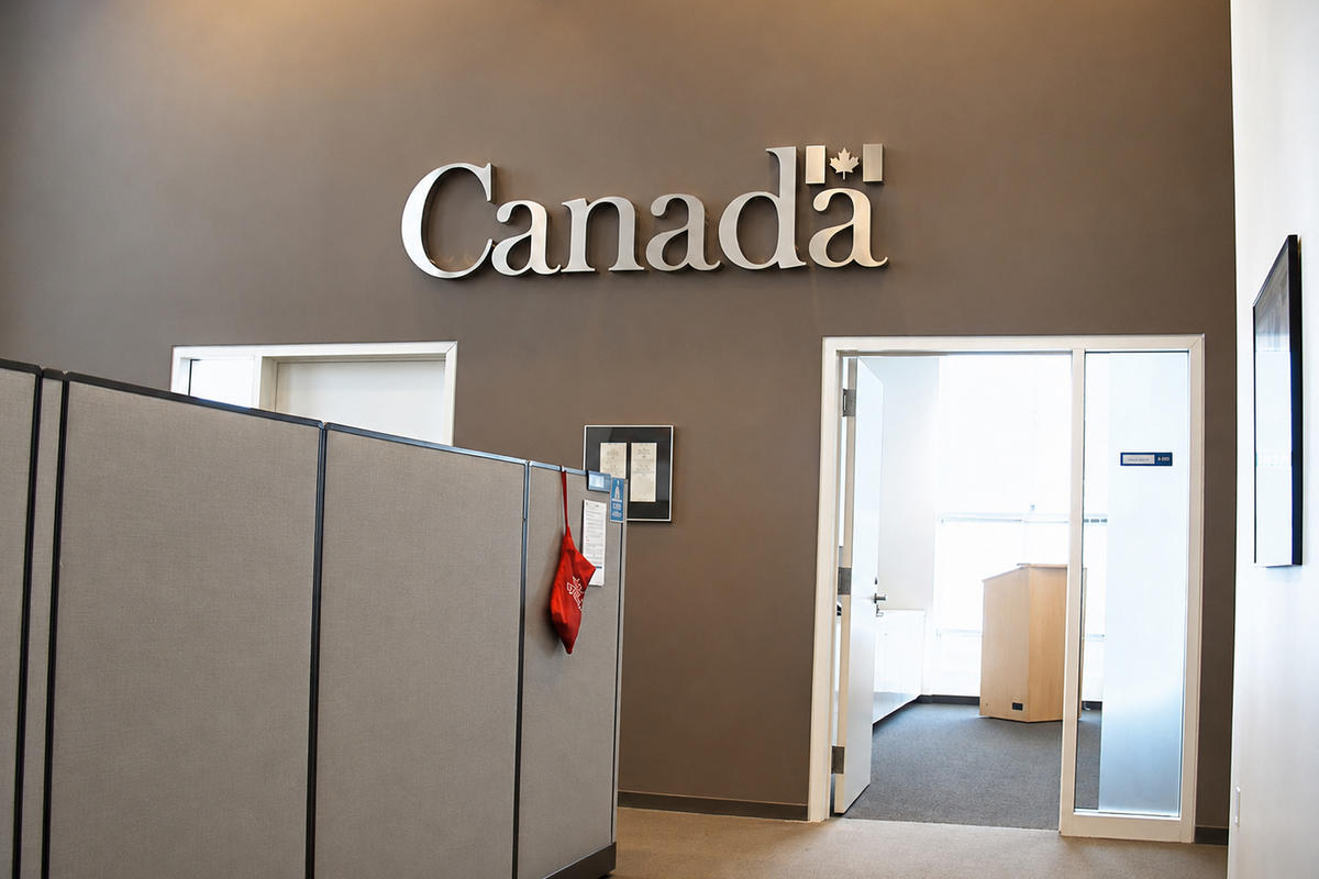 Brushed stainless steel Canada wordmark sign with maple leaf flag detail, hand-crafted 3-inch deep letters on a taupe wall