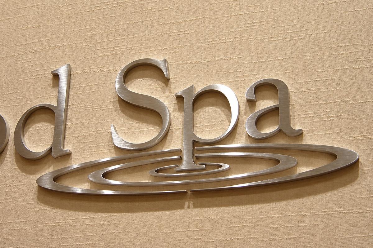 Close-up of brushed stainless steel Elmwood Spa letters and ripple logo