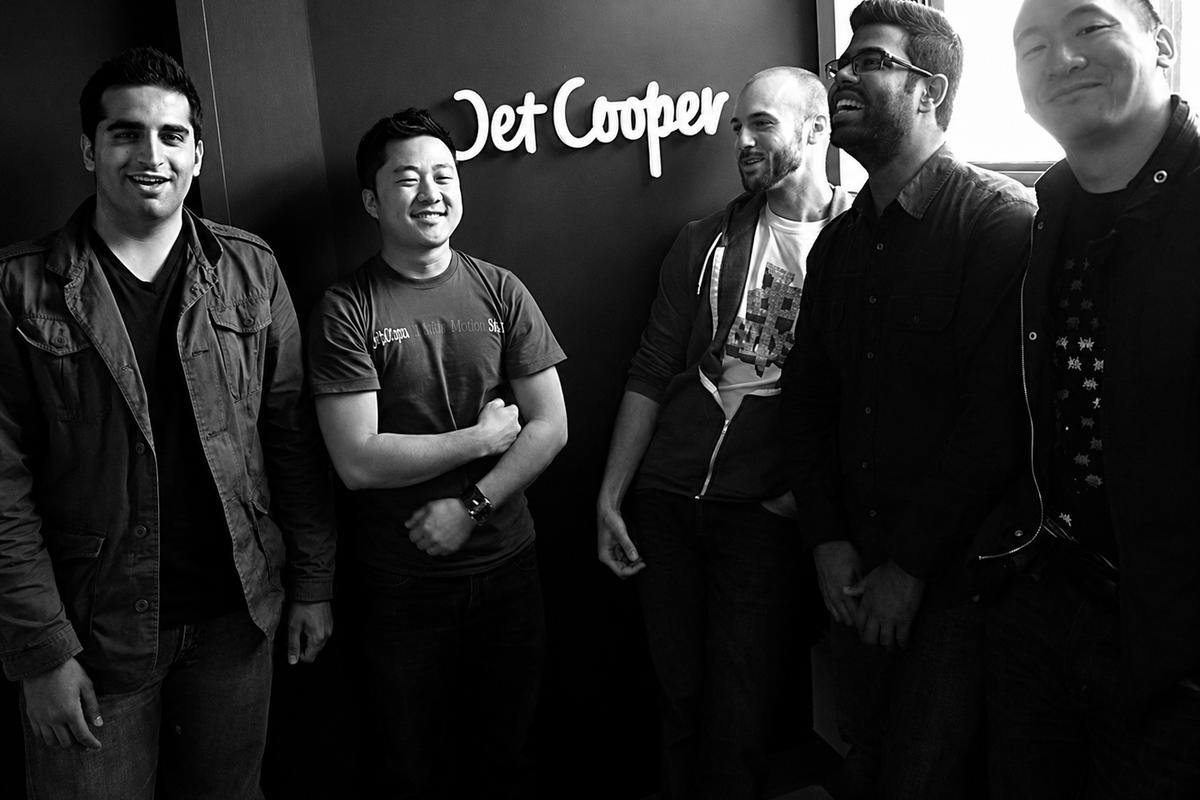Jet Cooper team standing beneath their custom pastel ice-white frosted acrylic office logo