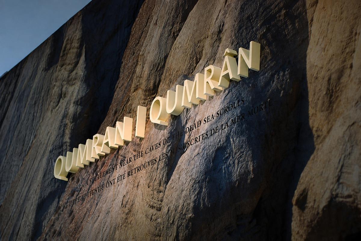 Cream Qumran lettering on rock-pattern printed wallpaper at the Royal Ontario Museum in Toronto.