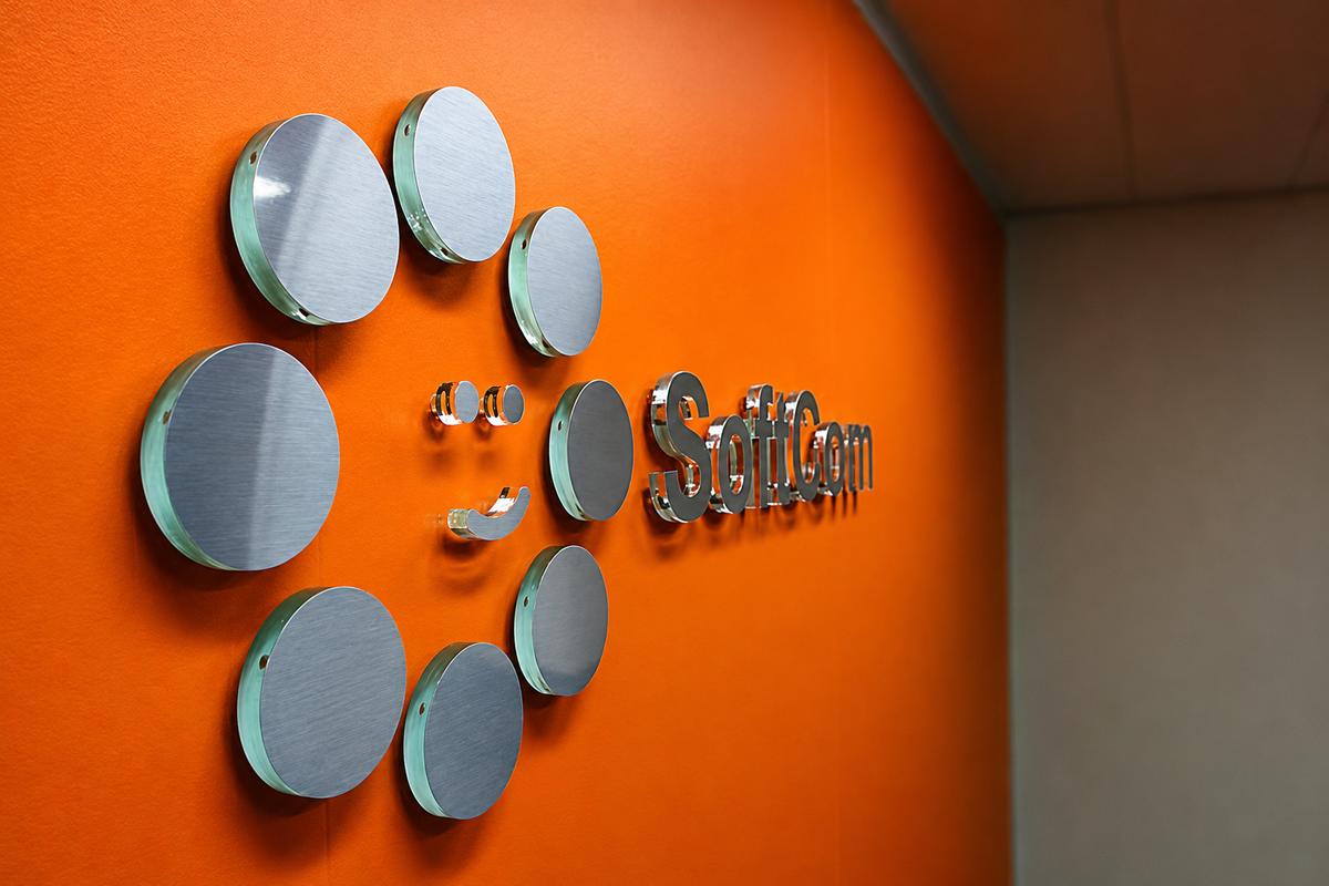 Side view of SoftCom 3D office sign with green edge acrylic, brushed metal faces, and clear spacers