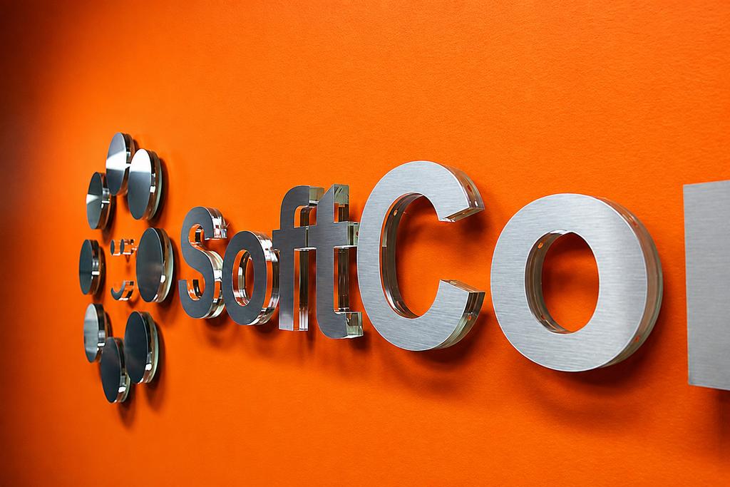 Angled close-up of SoftCom brushed metal dimensional letters with glass-like acrylic edges