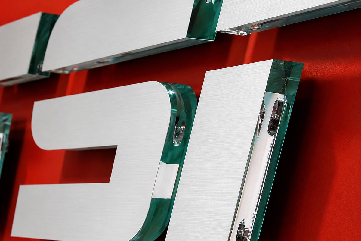 Close-up of the TSN logo showing ¾-inch green-edge acrylic and brushed-metal surfaces.
