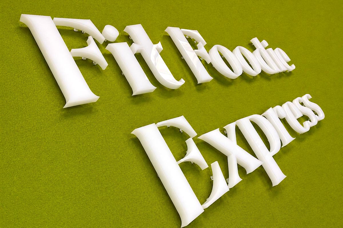 Fit Foodie Express sign made from 1-inch-thick glossy white acrylic dimensional letters with clear mounting hardware.