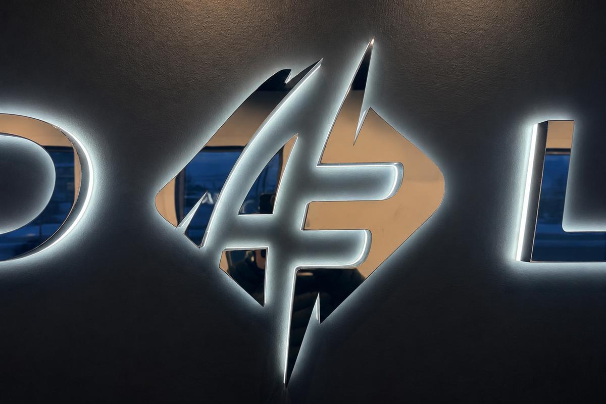 Close-up of the Auto Fusion lightning bolt logo in mirror chrome stainless steel with white LED halo lighting