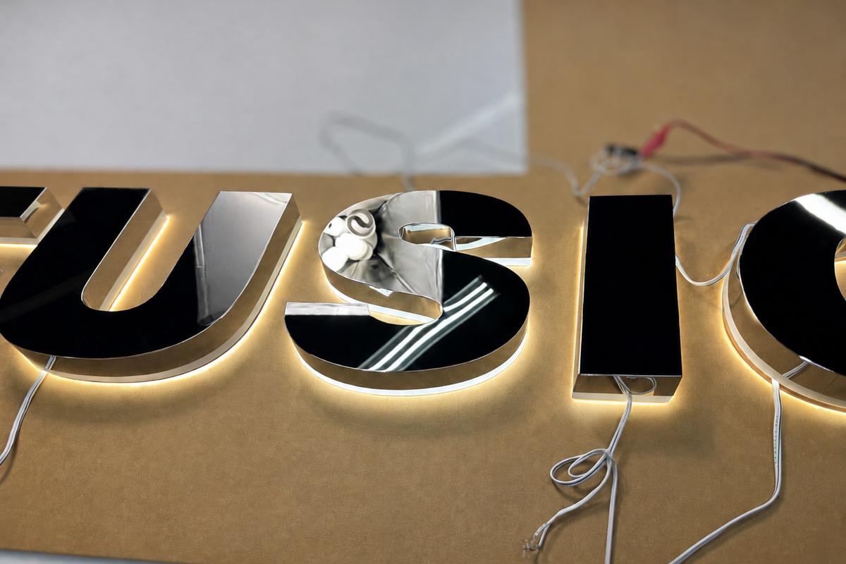Auto Fusion chrome stainless steel LED channel letters laid out on a production template before installation