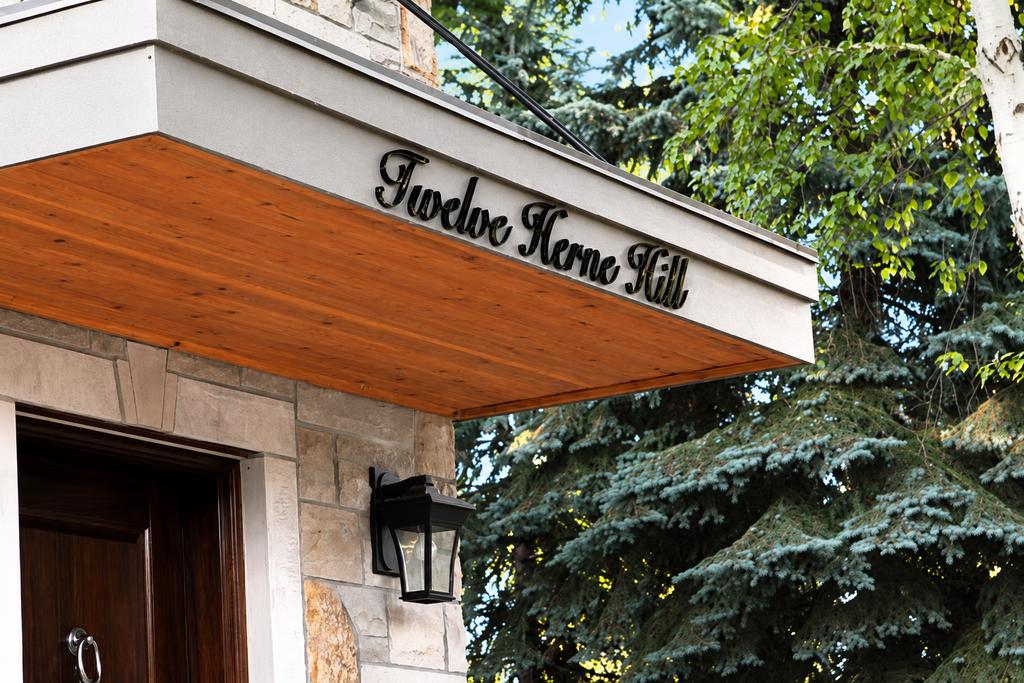 Oblique detail of Twelve Herne Hill glossy black acrylic script on an entrance canopy