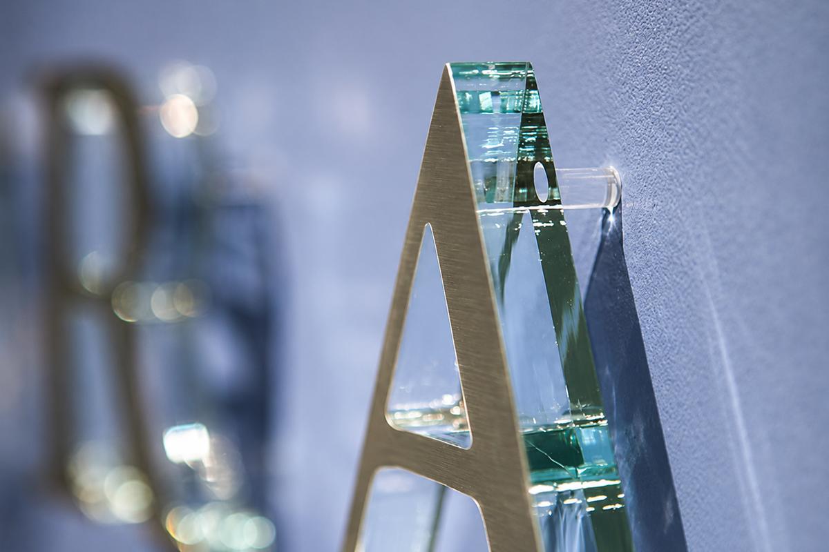 Side detail of green-edge acrylic sign letter mounted with a clear wall spacer