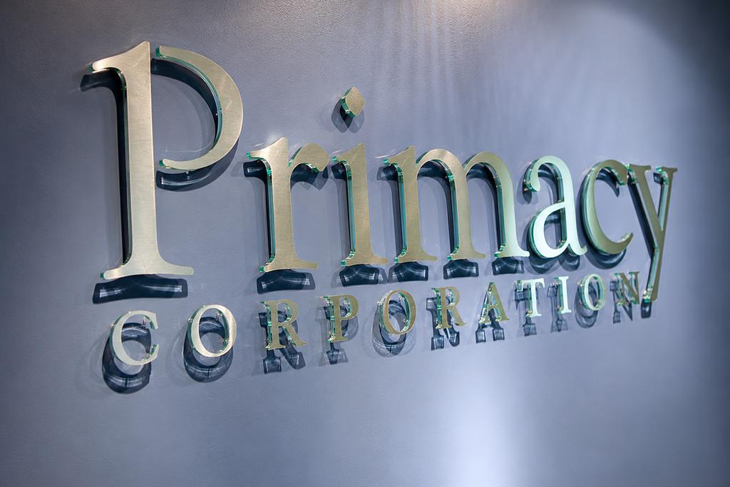 Close-up of Primacy office wall sign with brushed aluminum faces and clear acrylic edges