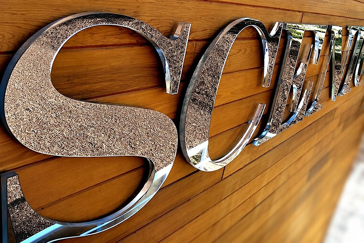 Close-up of 1/4-inch second-surface mirror acrylic laminated to clear acrylic with a water-clear polished edge against wood cladding